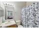 Bathroom with vanity and mirror, toilet, and shower with blue floral curtain at 104 Wilton Cir, Sanford, FL 32773