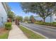 Gated entrance into a community with mature landscaping, trees, and blue buildings at 104 Wilton Cir, Sanford, FL 32773