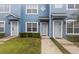 Inviting blue townhome with well-maintained landscaping and charming front entrances at 104 Wilton Cir, Sanford, FL 32773