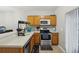 Functional kitchen with wood cabinets, stainless steel appliances, and a view of the dining area at 104 Wilton Cir, Sanford, FL 32773