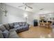 Open-concept living area featuring hardwood floors, a cozy sofa, and a dining area with a chandelier at 104 Wilton Cir, Sanford, FL 32773