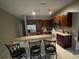 Eat-in kitchen with dark wood cabinets, granite counters, stainless appliances, and tile floors at 117 Anzio Dr, Kissimmee, FL 34758