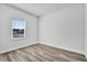 Simple bedroom featuring wood floors and natural light from a window at 13594 Sw 40 Cir, Ocala, FL 34473