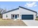 Charming single-story home with a modern blue door and a well-maintained gray stucco exterior at 13594 Sw 40 Cir, Ocala, FL 34473