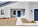 Welcoming entryway featuring a blue front door, white trim, and a neatly landscaped yard at 13594 Sw 40 Cir, Ocala, FL 34473