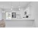 Open kitchen with white quartz countertops, stainless steel appliances and an island with pendant lighting at 13594 Sw 40 Cir, Ocala, FL 34473