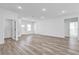 Bright living room with hardwood floors and white walls, leading to the bathroom and front door at 13594 Sw 40 Cir, Ocala, FL 34473