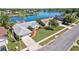 An aerial view of a house with a well-kept yard and a serene lake in the background, surrounded by other homes at 14772 Eagles Crossing Dr, Orlando, FL 32837