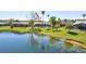 A serene backyard featuring a lush lawn, screened lanai, pool, and tranquil lake views at 14772 Eagles Crossing Dr, Orlando, FL 32837