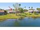 Backyard view of a home with a screened-in lanai, lush green lawn, and waterfront access at 14772 Eagles Crossing Dr, Orlando, FL 32837
