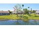 Waterfront backyard featuring a screened-in lanai, mature trees, and lush green lawn at 14772 Eagles Crossing Dr, Orlando, FL 32837