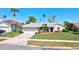 Charming single-story home with a well-manicured lawn and a two-car garage, complemented by palm trees at 14772 Eagles Crossing Dr, Orlando, FL 32837