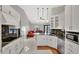 Well-lit kitchen features granite counters, white cabinets, stainless appliances, and open to living area at 14772 Eagles Crossing Dr, Orlando, FL 32837