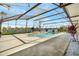 A screened-in pool sits in a backyard overlooking the calm lake at 14772 Eagles Crossing Dr, Orlando, FL 32837