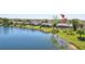 Lush waterfront backyard featuring a screened-in lanai, mature trees, and well-maintained landscaping at 14772 Eagles Crossing Dr, Orlando, FL 32837