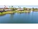 Beautiful waterfront view of a home with a screened-in lanai and lush green lawn at 14772 Eagles Crossing Dr, Orlando, FL 32837