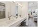 Bright bathroom featuring a double sink vanity, large mirror, and tile flooring at 1552 Fairview Cir, Reunion, FL 34747