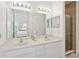 Large bathroom with double sinks, framed mirrors, vanity lighting and walk-in shower at 1552 Fairview Cir, Reunion, FL 34747