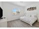 Bright bedroom featuring a queen bed, wood-look floors, and a window, creating a serene and inviting space at 1552 Fairview Cir, Reunion, FL 34747