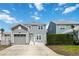 Exterior view of the two-story gray home featuring a garage and fenced-in yard, offering both privacy and curb appeal at 1552 Fairview Cir, Reunion, FL 34747