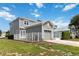 Exterior view of the two-story gray home featuring a garage and fenced-in yard, offering both privacy and curb appeal at 1552 Fairview Cir, Reunion, FL 34747