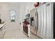 Modern kitchen with stainless steel appliances, white cabinets, and tile flooring at 1552 Fairview Cir, Reunion, FL 34747