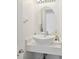 Stylish powder room featuring a sleek, modern vessel sink and an oval mirror at 1552 Fairview Cir, Reunion, FL 34747