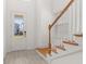 Bright foyer with wood stairs and a view through the glass-paneled front door at 16294 Honey Harvest St, Winter Garden, FL 34787