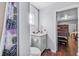 Well-lit bathroom featuring a vanity, toilet, shower with a floral curtain, and a glimpse of an adjacent bedroom at 1716 2Nd Ne St, Winter Haven, FL 33881