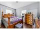 Bedroom featuring a wooden bed frame, a dresser with decor, hardwood floors, and two windows at 1716 2Nd Ne St, Winter Haven, FL 33881