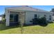 Backyard view of the home with sliding glass doors, a small grill and trees at 179 Blue Cypress Dr, Davenport, FL 33837