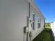 Exterior view of the home featuring the stucco siding, meter and two windows at 179 Blue Cypress Dr, Davenport, FL 33837