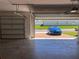Spacious garage with a blue car parked outside on the brick paved driveway at 179 Blue Cypress Dr, Davenport, FL 33837