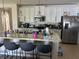 Eat-in kitchen with white cabinets, stainless steel appliances, and a marble-topped island with bar stool seating at 179 Blue Cypress Dr, Davenport, FL 33837