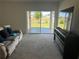 Living room with a plush sofa and sliding glass doors leading to outdoor space and green lawn at 179 Blue Cypress Dr, Davenport, FL 33837