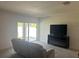 Bright living room featuring carpet floors, sliding glass doors to outdoor space and flat screen TV at 179 Blue Cypress Dr, Davenport, FL 33837