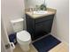 Powder room with a small vanity, sink, mirror, toilet and a blue rug at 179 Blue Cypress Dr, Davenport, FL 33837