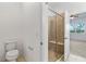 Bathroom featuring glass enclosed shower with seat, toilet, and view of the bedroom at 1830 Estuary Ln, Kissimmee, FL 34747