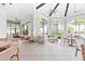 A dining area with arched windows, ceiling fans and wicker furniture at 1830 Estuary Ln, Kissimmee, FL 34747