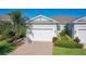 Home with manicured lawn and colorful landscaping, showcasing its well-maintained curb appeal under a clear blue sky at 1830 Estuary Ln, Kissimmee, FL 34747