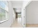 Bright hallway with neutral tile floors and an open doorway leading to the living area with outdoor views at 1830 Estuary Ln, Kissimmee, FL 34747