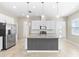 Bright kitchen with stainless steel appliances, tiled backsplash, and granite countertops on the kitchen island at 1830 Estuary Ln, Kissimmee, FL 34747