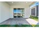 A covered patio features a brick-paved floor and sliding glass doors to the home's interior at 1830 Estuary Ln, Kissimmee, FL 34747