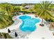 Aerial view of a cloverleaf shaped pool surrounded by palm trees and lounge chairs at 1830 Estuary Ln, Kissimmee, FL 34747
