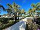 Landscaped walkway leads to the community pool and clubhouse, shaded by palm trees at 1830 Estuary Ln, Kissimmee, FL 34747