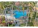 Aerial view of a trefoil-shaped pool, pergola, and lush tropical landscaping at 188 Olympus Way, Kissimmee, FL 34759