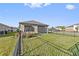Fenced backyard with grassy lawn and view of the rear exterior at 188 Olympus Way, Kissimmee, FL 34759