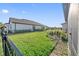 Grassy backyard, enclosed by a black metal fence at 188 Olympus Way, Kissimmee, FL 34759