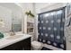 Well-lit bathroom with vanity, toilet and shower with flower patterned curtain at 188 Olympus Way, Kissimmee, FL 34759