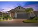 Charming single-story home featuring a brick driveway, two-car garage, and beautiful landscaping at 188 Olympus Way, Kissimmee, FL 34759